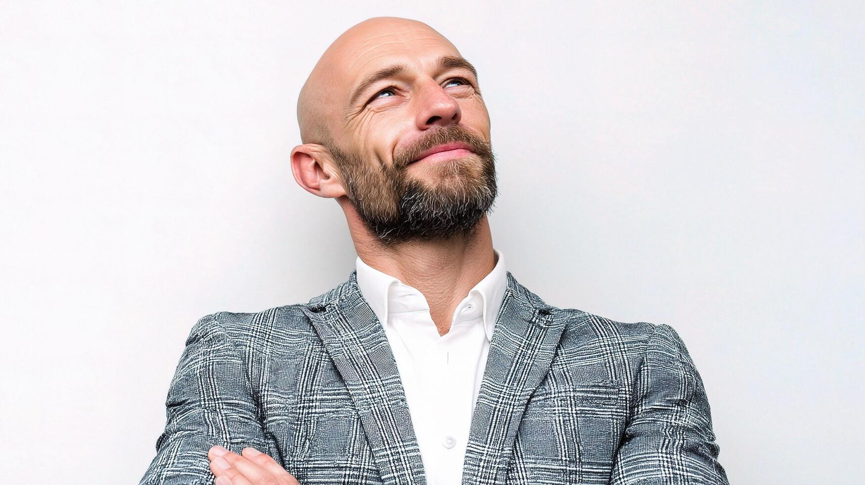 A bald man with a beard and suit jacket photo