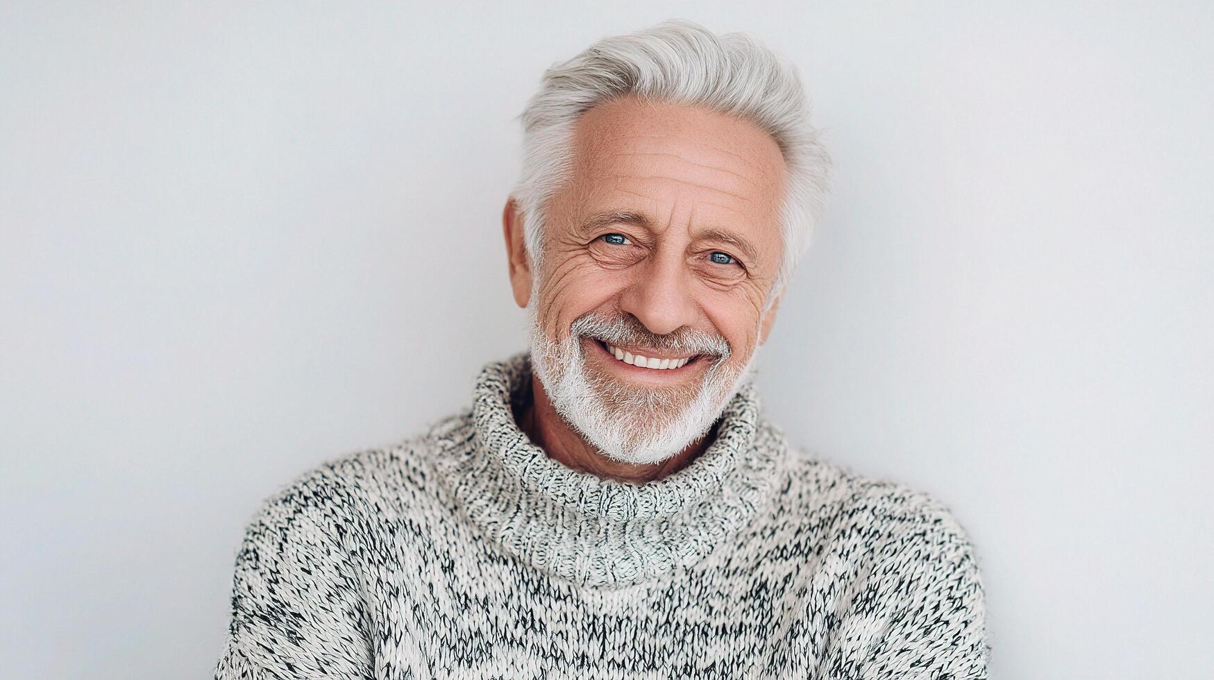 A man with a white beard and sweater smiling photo