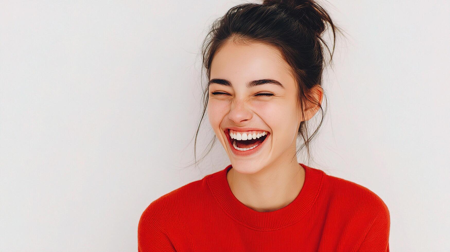 A woman laughing and smiling in a red sweater photo