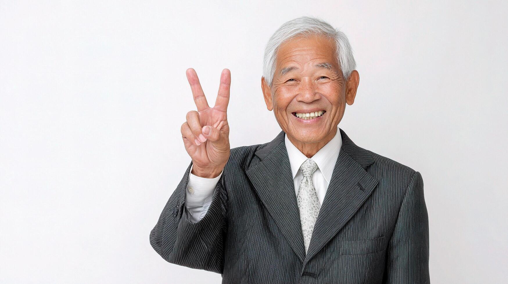 An older man in a suit and tie making the peace sign photo