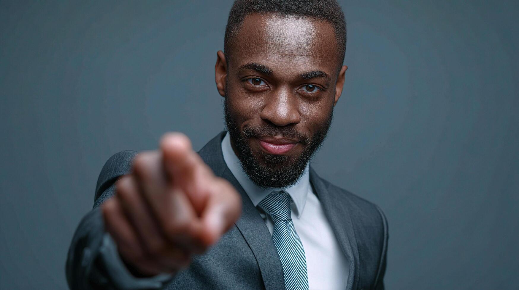 A black man in a suit pointing at the camera photo