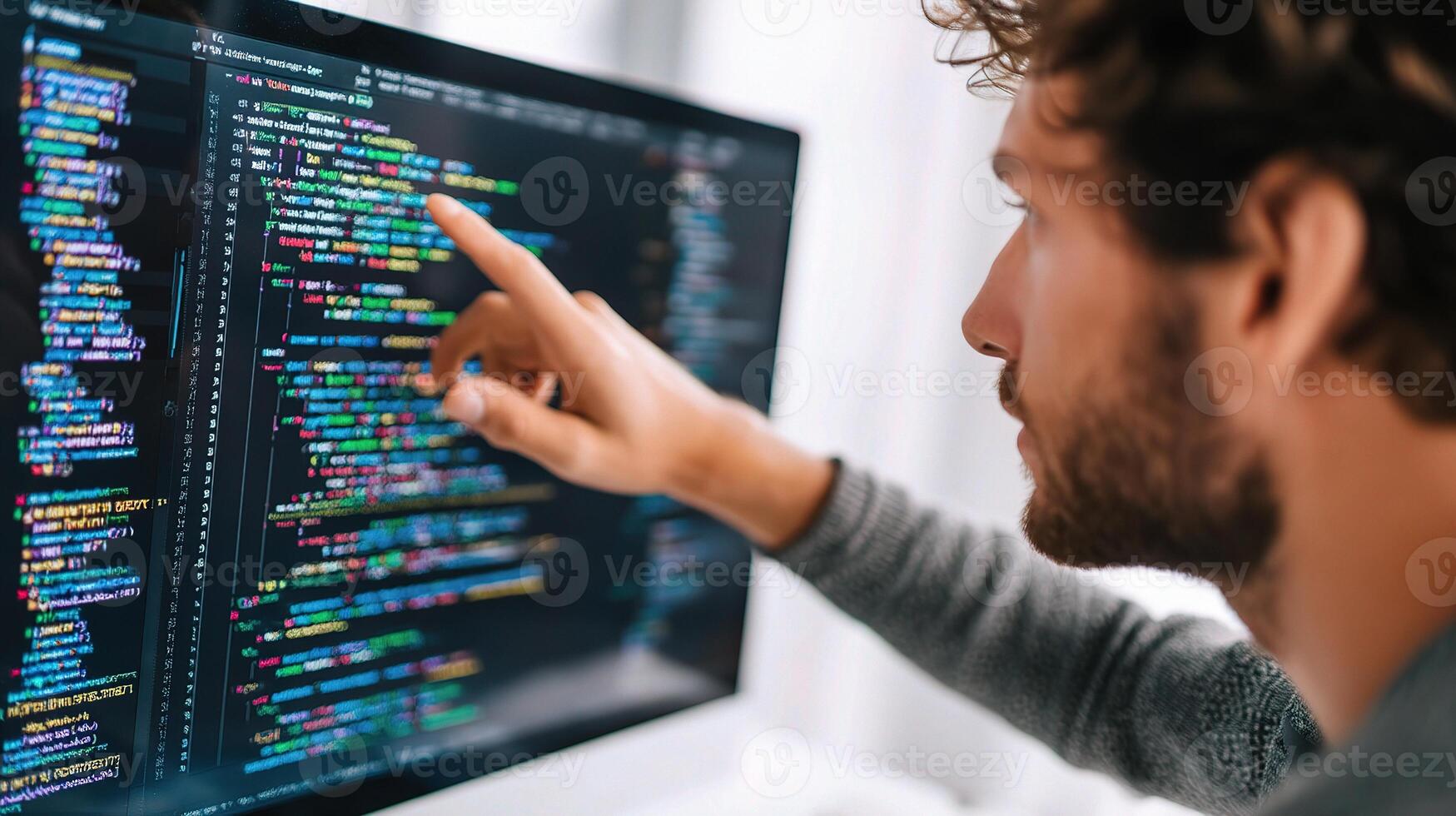 A man pointing at a computer screen with code on it photo