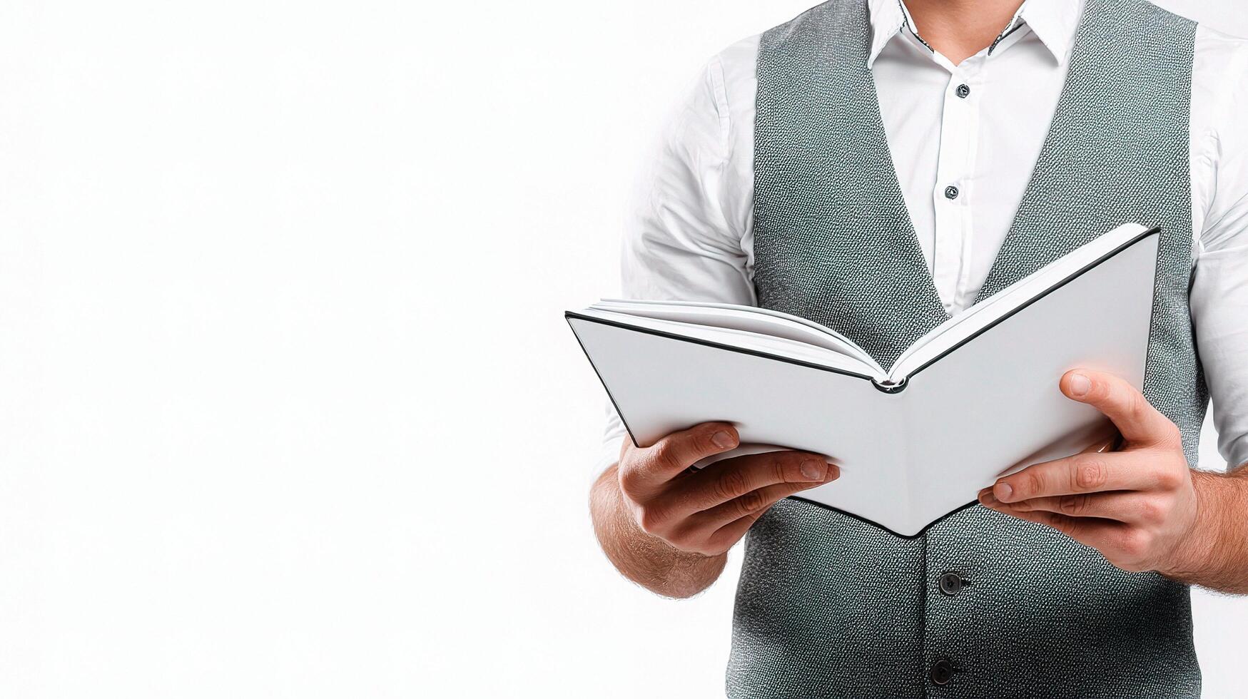 A man in a vest holding an open book photo