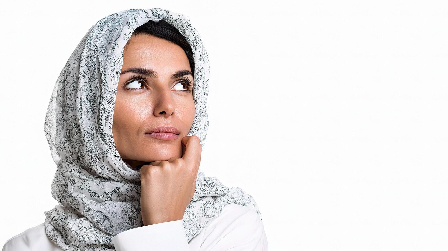 A woman wearing a headscarf looking up photo
