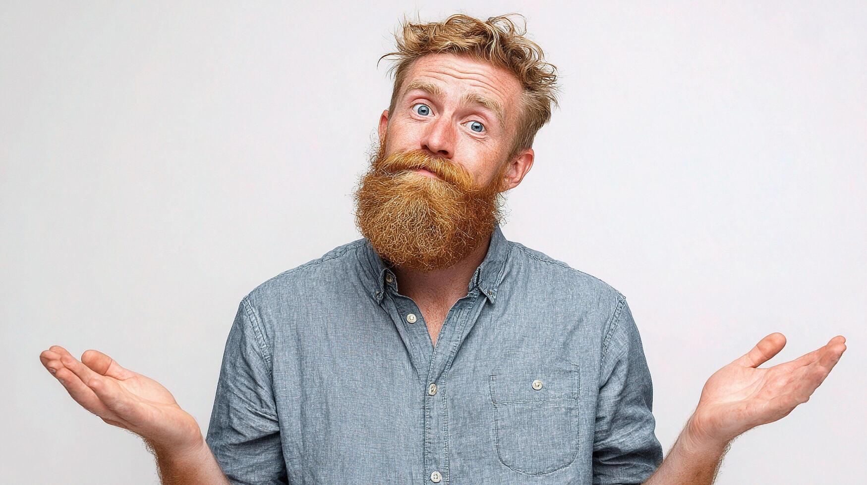 A man with a beard and a shirt is holding his hands up photo