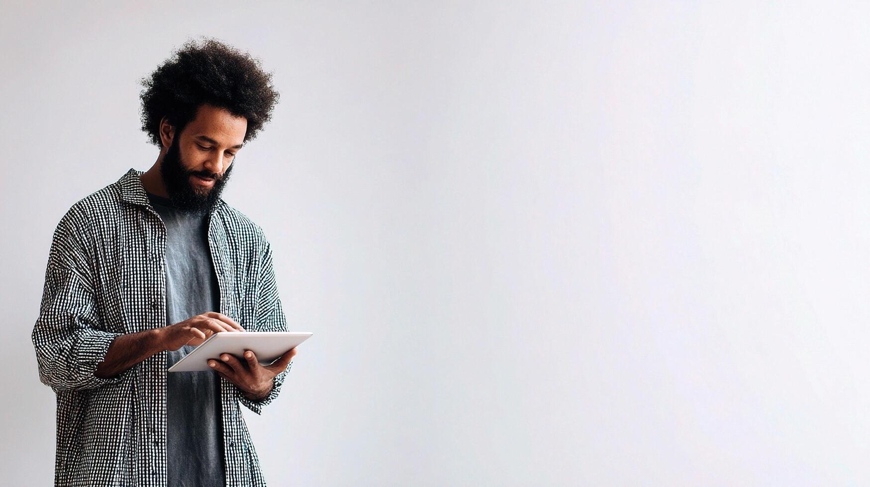 A man with a beard and a shirt is holding a tablet photo