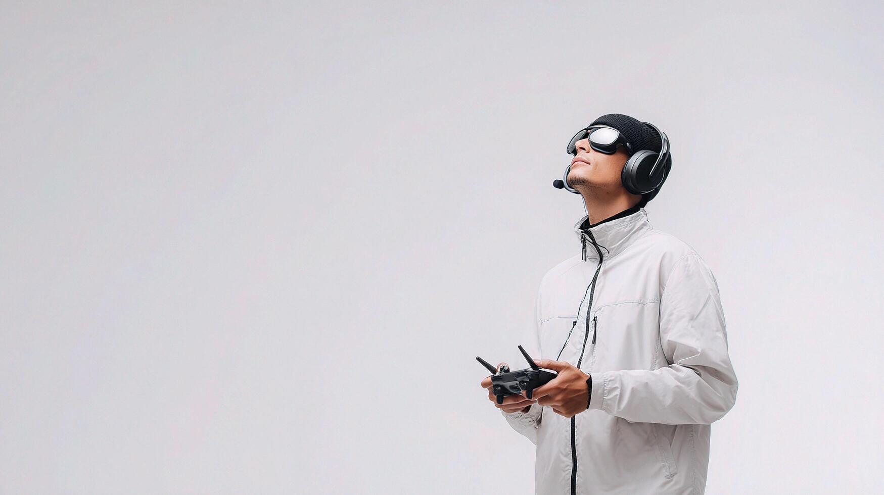 A man in a white jacket and goggles holding a remote control photo