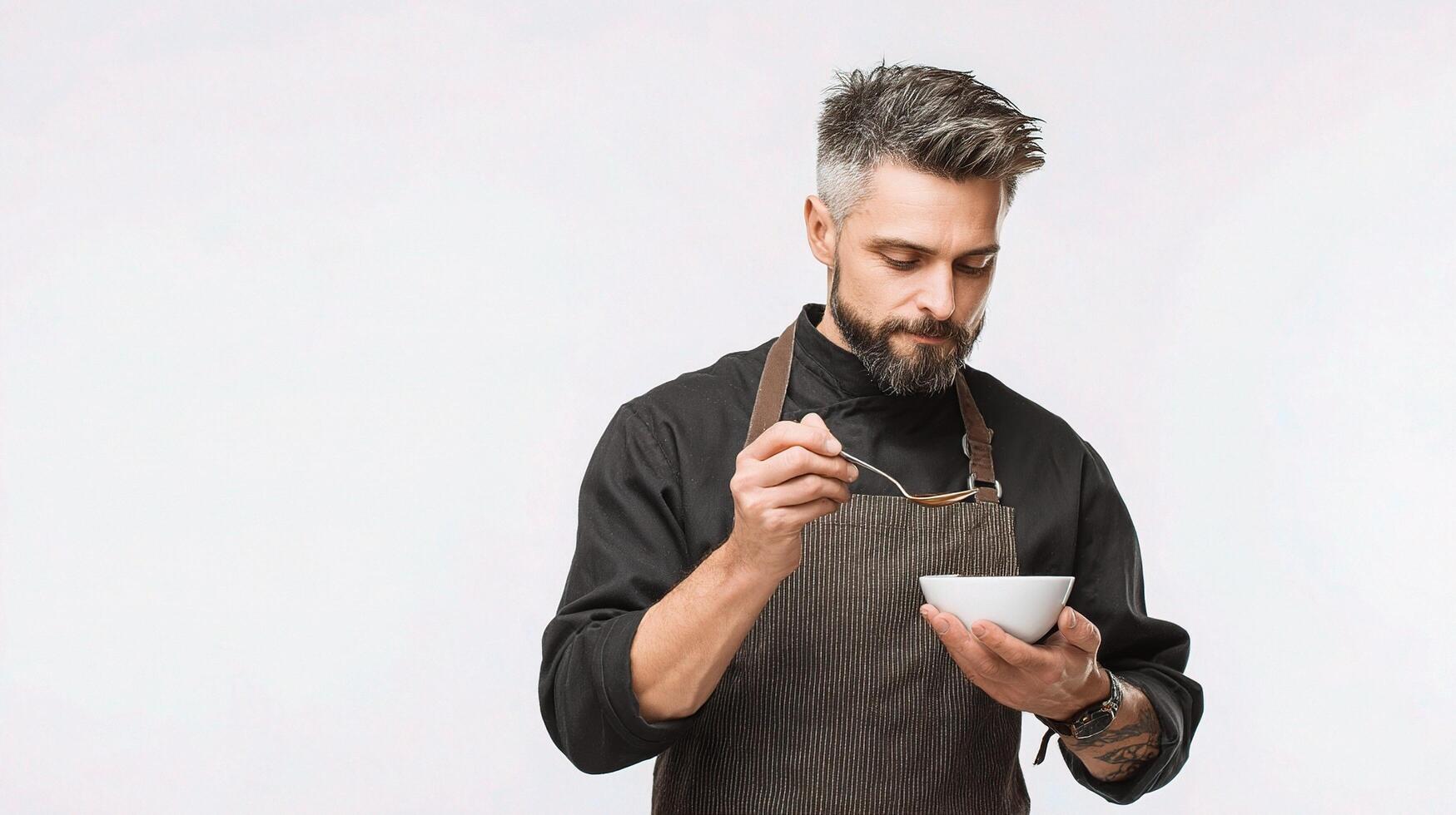 A man in an apron holding a bowl of soup photo