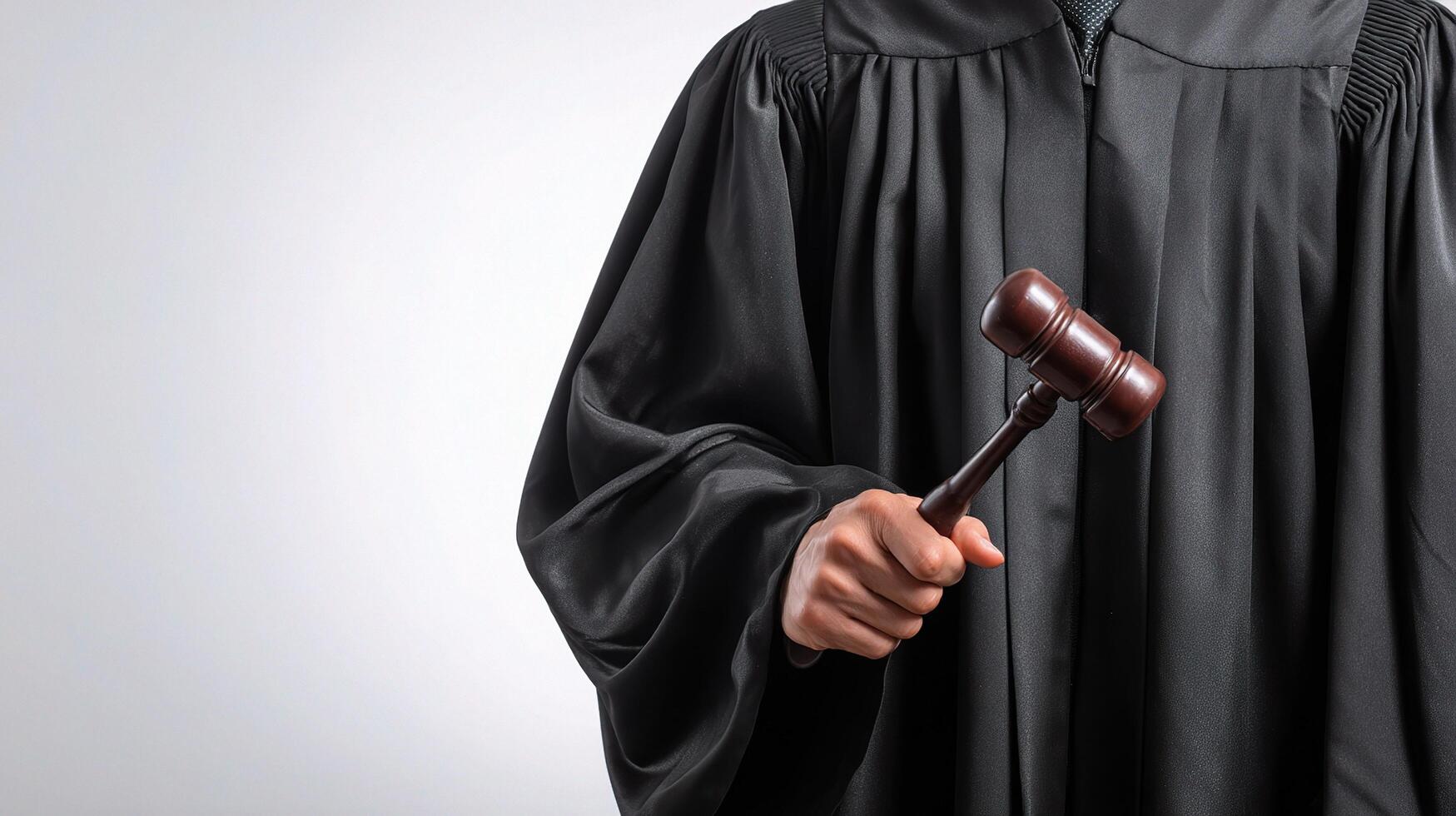 A judge holding a gavel and wearing a robe photo