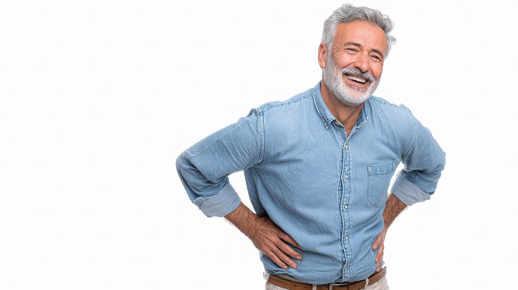 A man with back pain standing with his hands on his hips photo