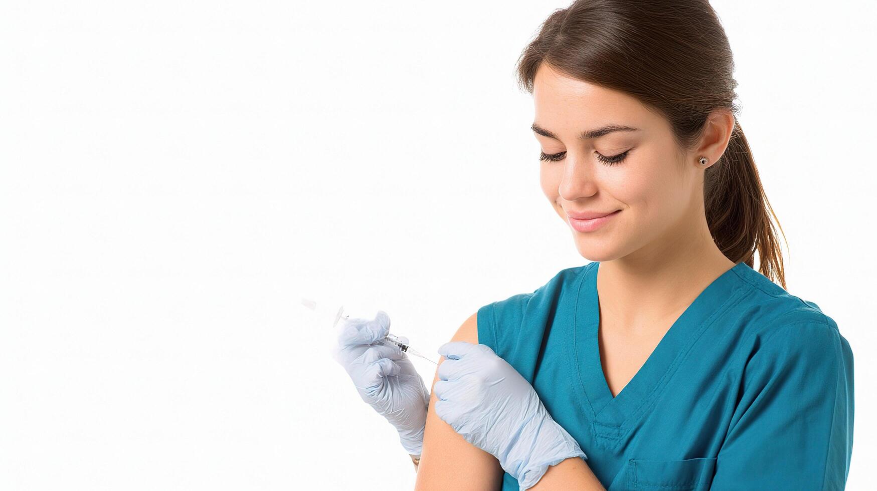 A woman in a blue scrub suit is holding an injection photo