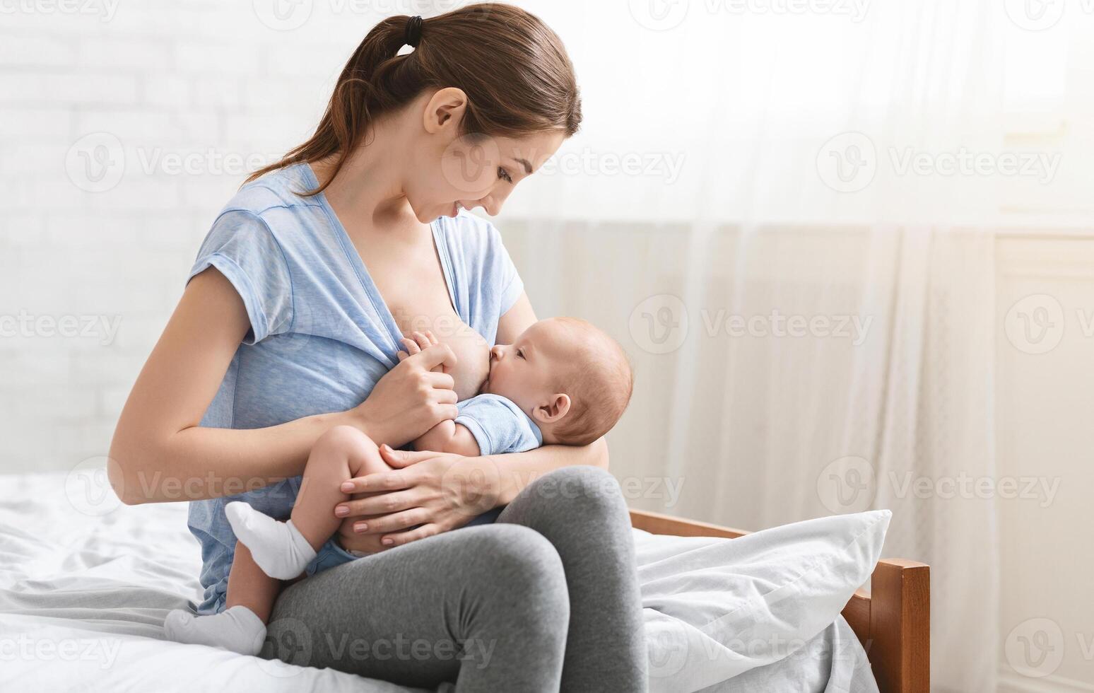 Baby eating milk before he sleeping, mother breastfeeding newborn kid at home, empty space photo