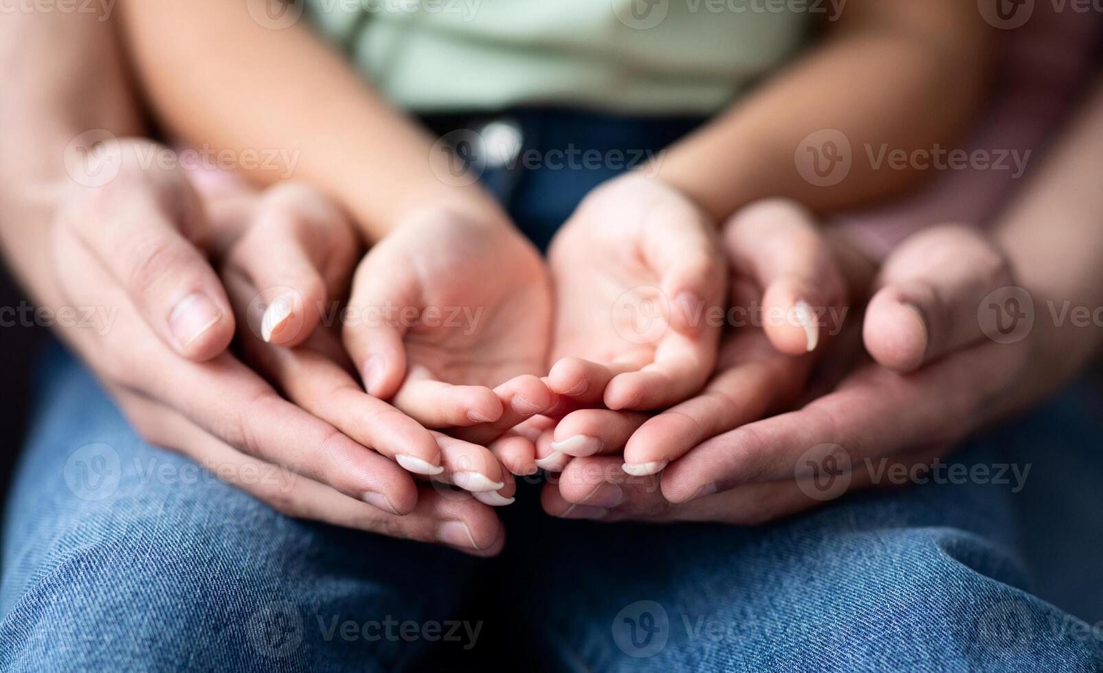 Parents and child placing their hands together, closeup shot. Conceptual image for family support, unity and love, selective focus at three pair of palms photo