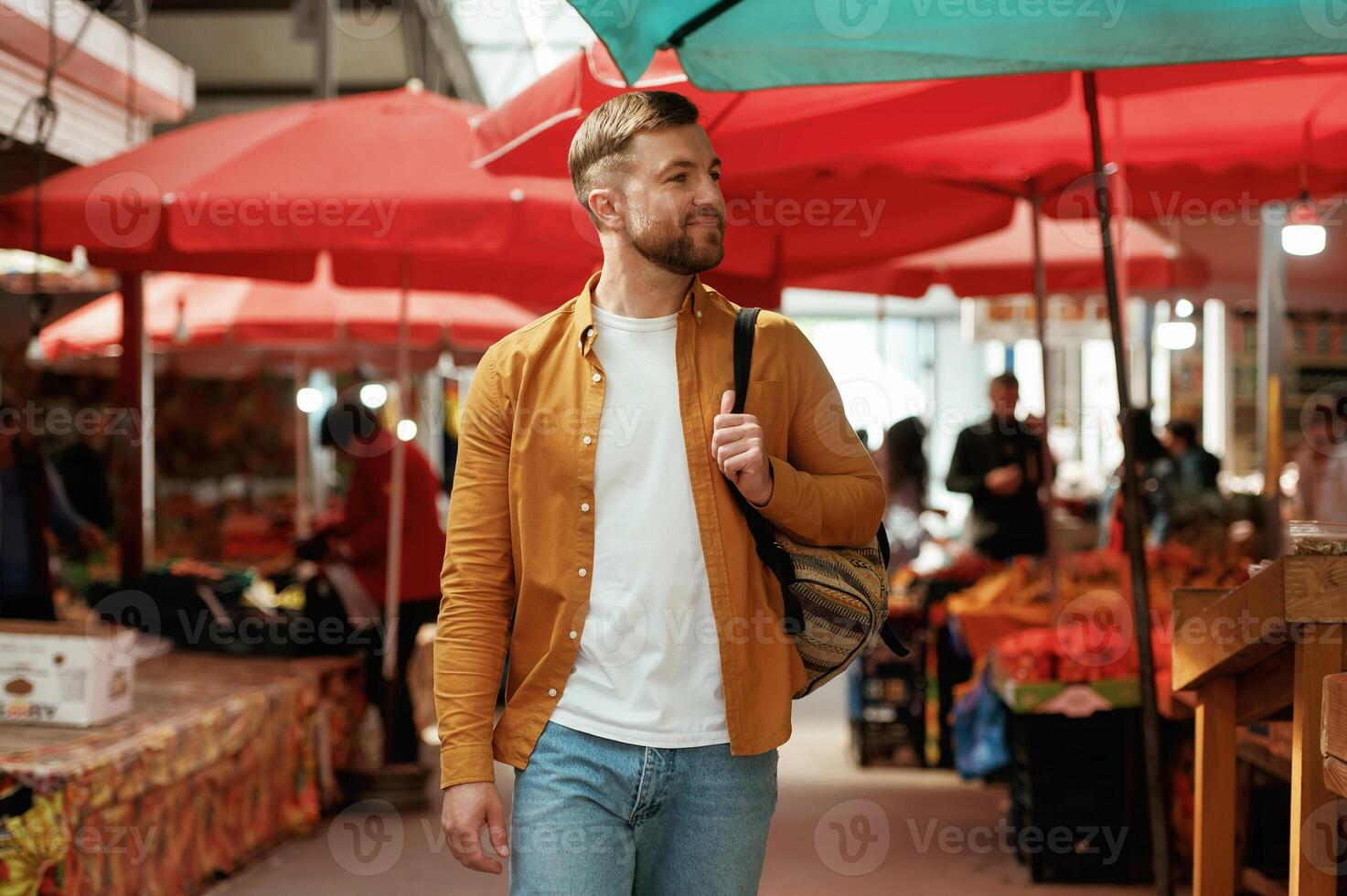 Going forward, looking at, products. Handsome man is on the street market or bazaar photo