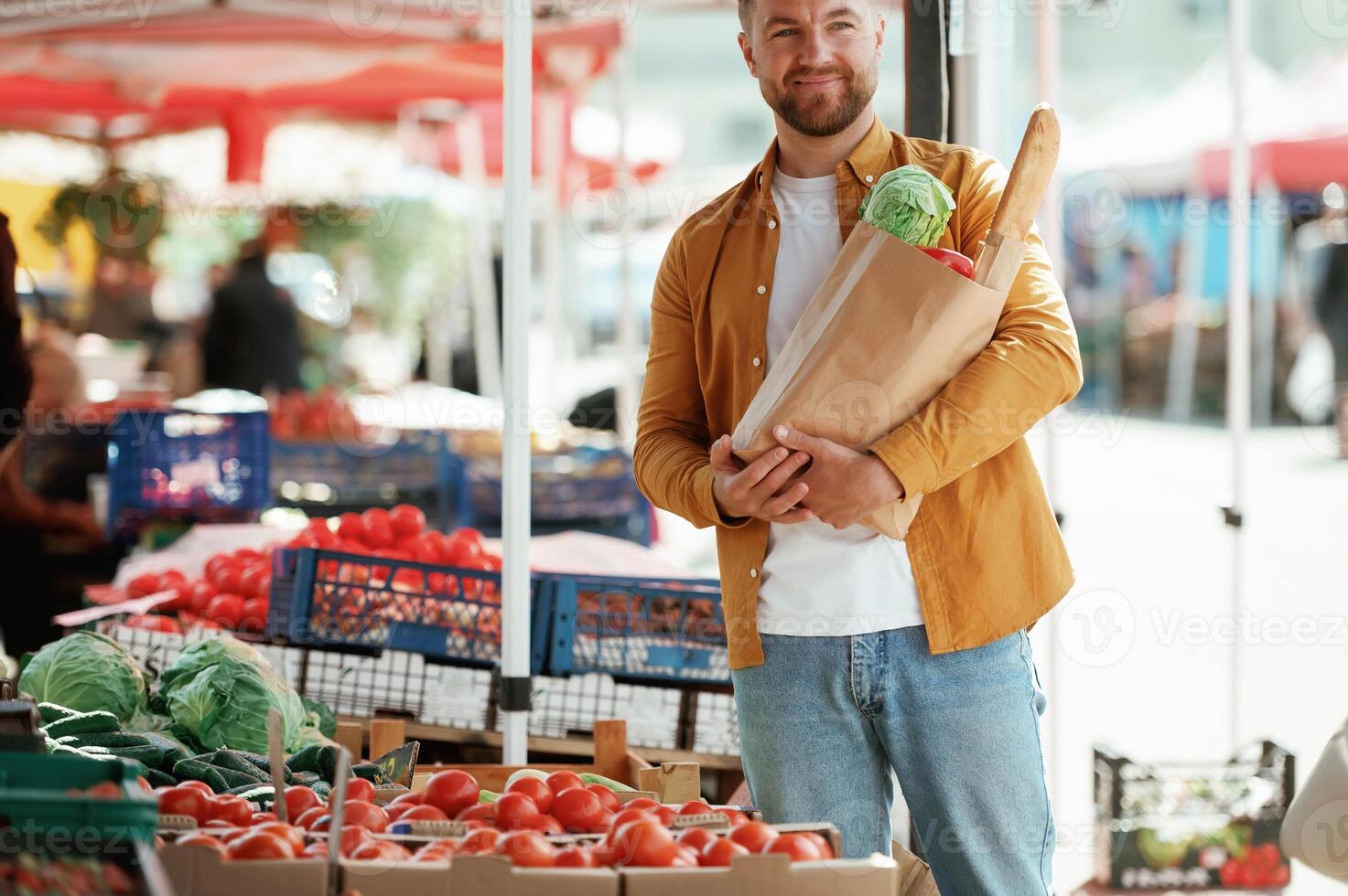 Collection of products, in paper bag. Handsome man is on the street market or bazaar photo