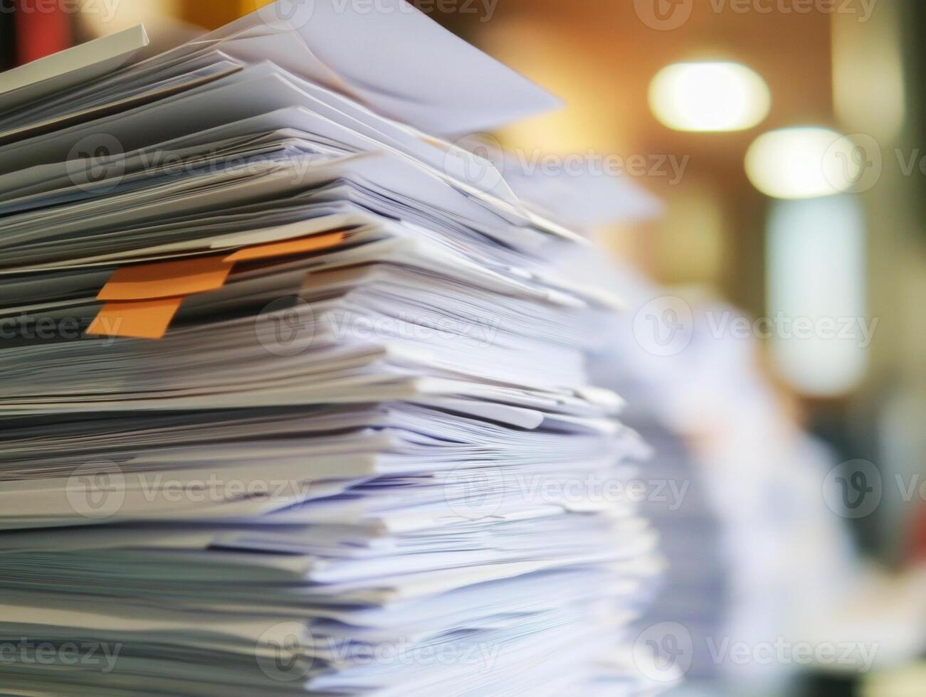 Piles of documents stacked on a desk in a busy office environment photo