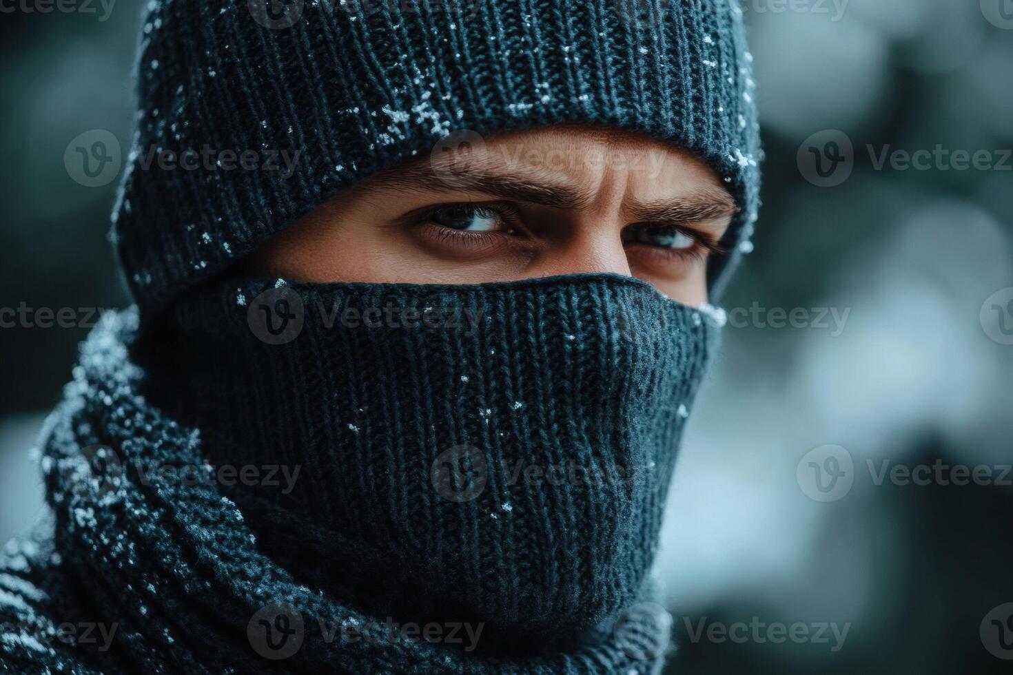 Man in warm clothing gazes intensely during a snowy winter day photo