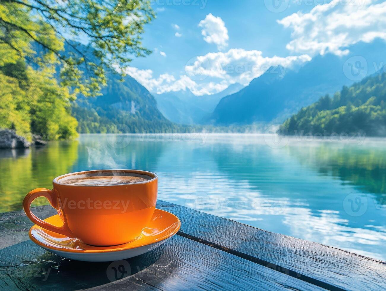 Coffee by a tranquil lake with mountains in the background photo