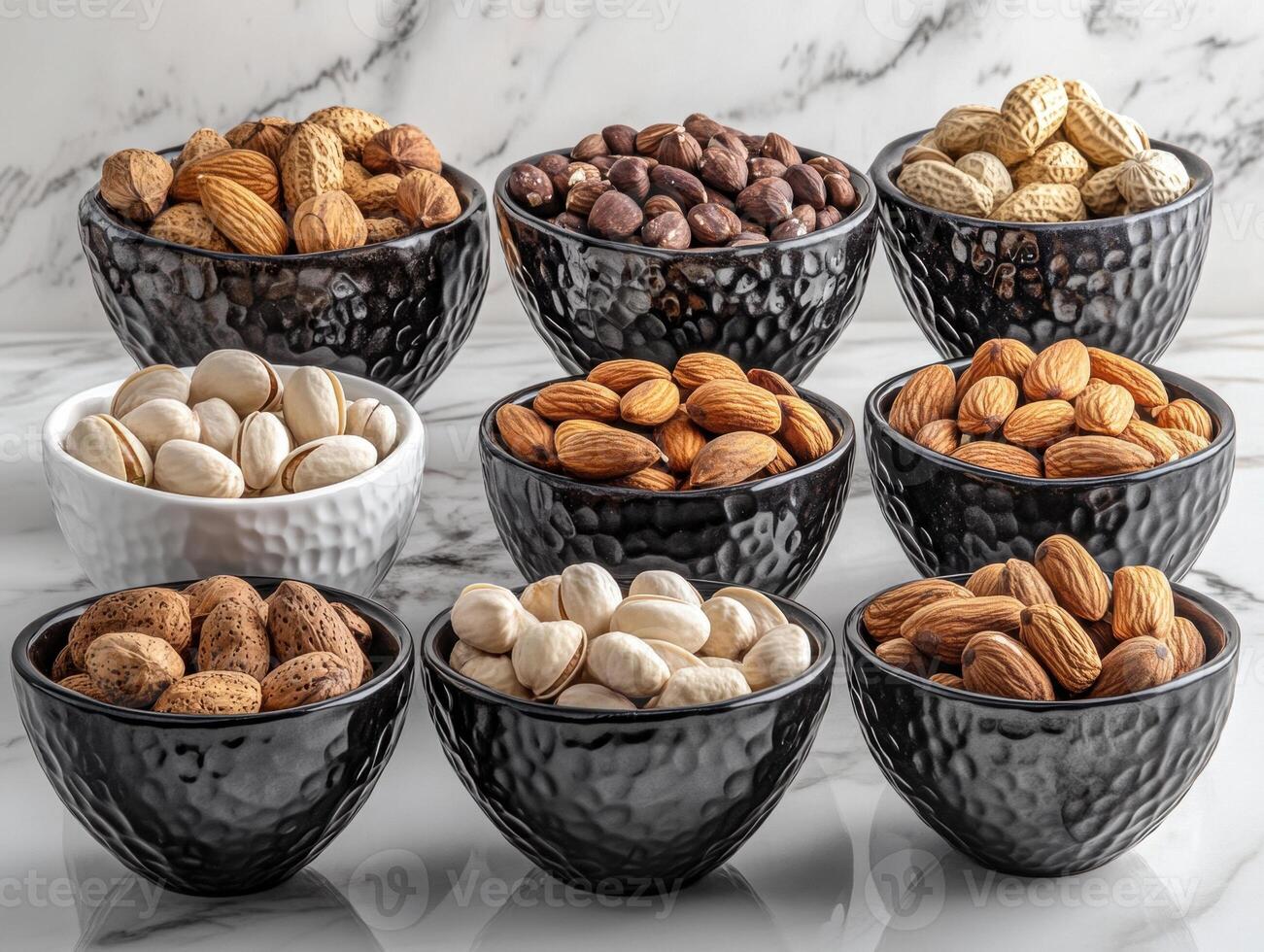 Various nuts displayed in decorative bowls on marble surface photo