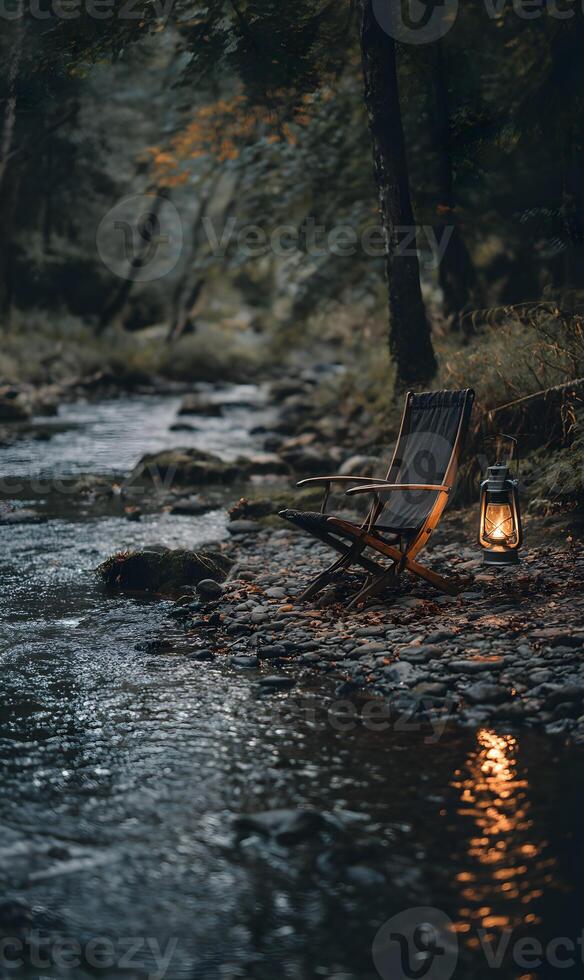 Cozy riverside retreat featuring a vintage chair and glowing lantern in a serene forest setting photo