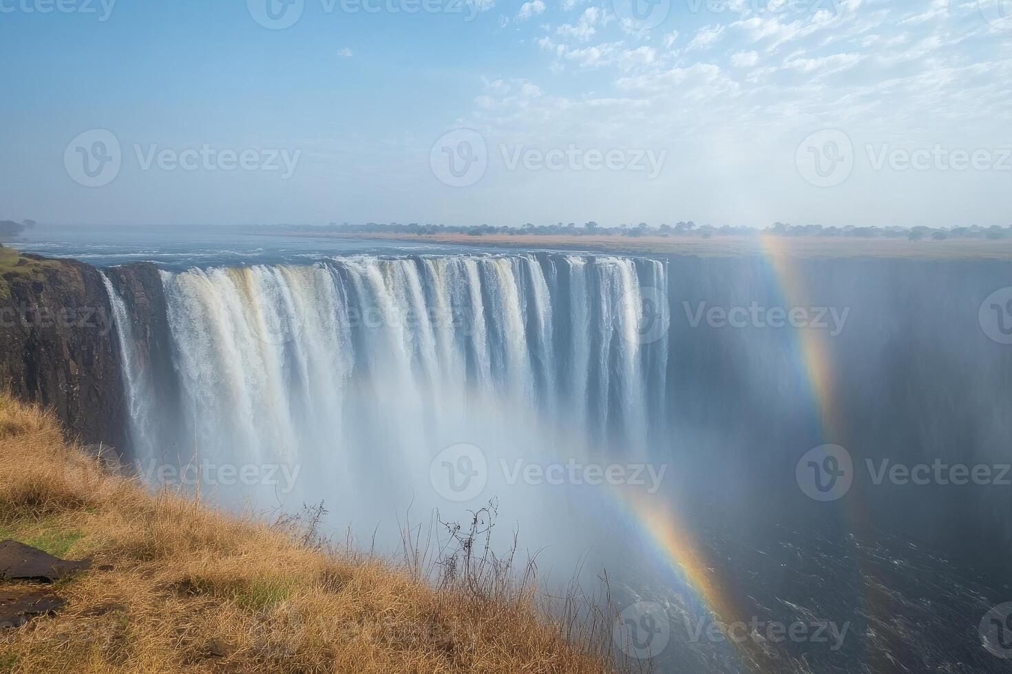 Victoria falls creating a double rainbow over zambezi river photo