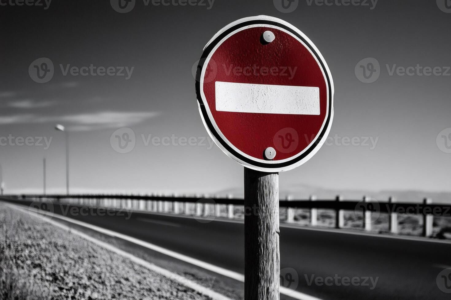 No entry sign stands guarding empty road on cloudy day photo