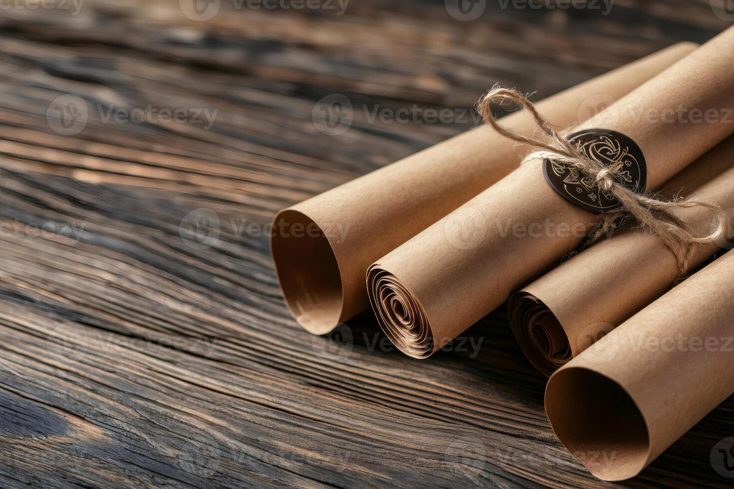 Old rolled paper scrolls tied with string and wax seal on rustic wooden table photo