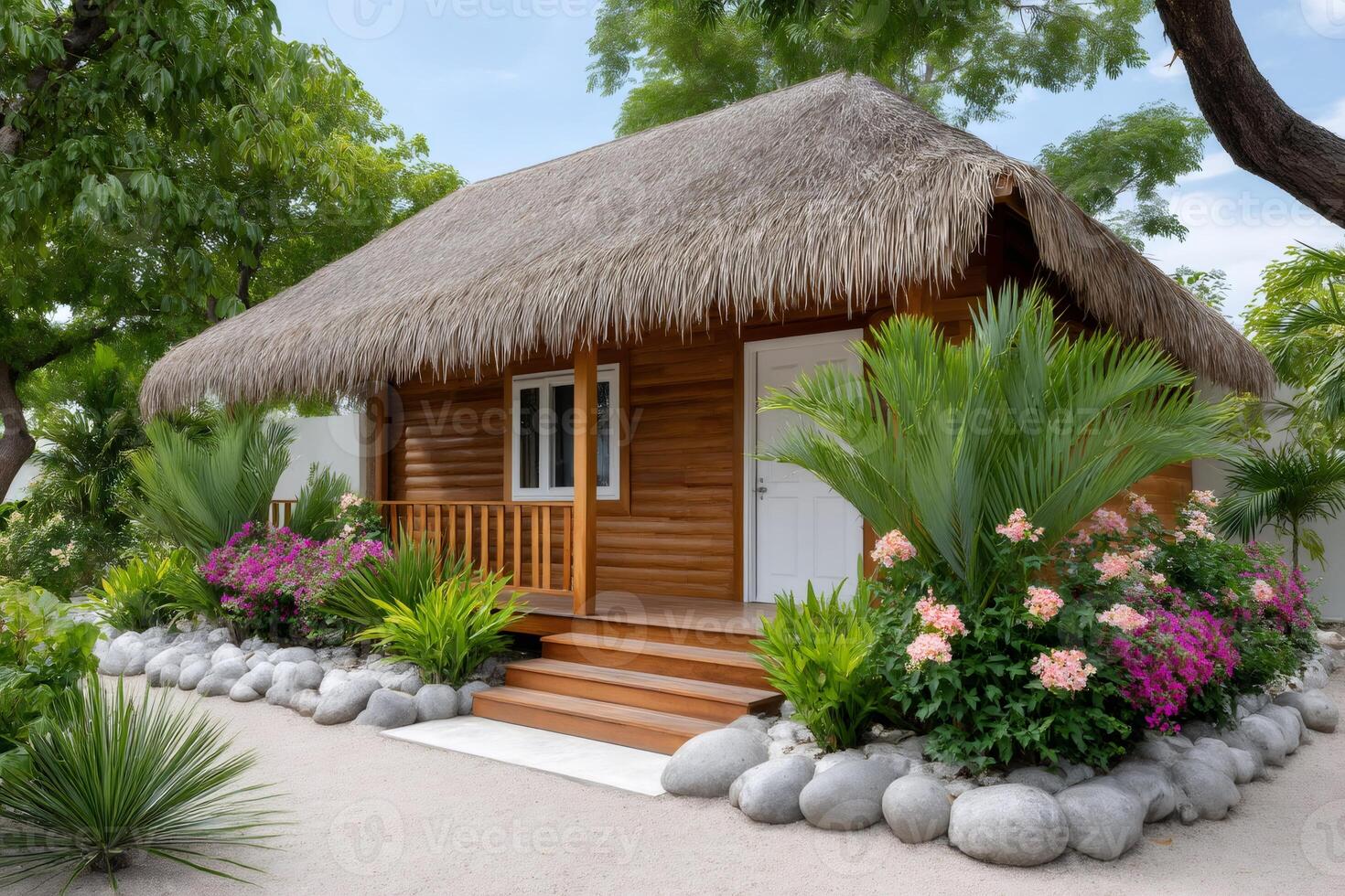 Tropical bungalow with thatched roof surrounded by lush vegetation photo