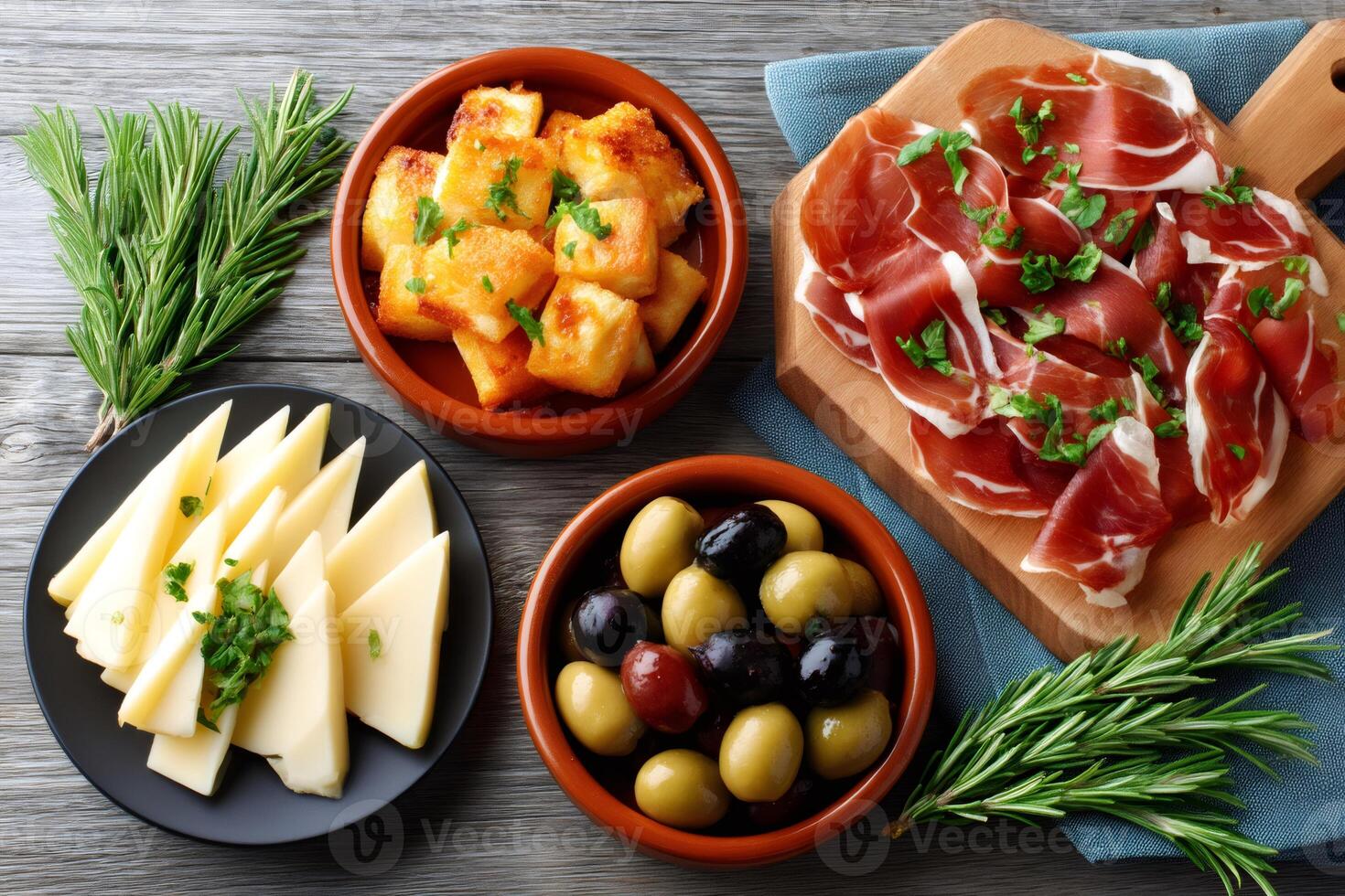 Spanish tapas with manchego cheese, serrano ham, olives and fried cheese served on a wooden table photo