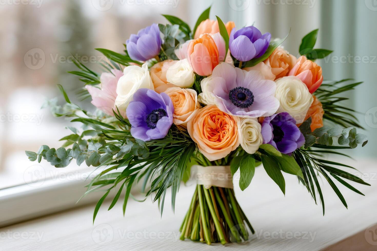 Colorful bouquet of anemone, roses and tulips resting on a windowsill photo