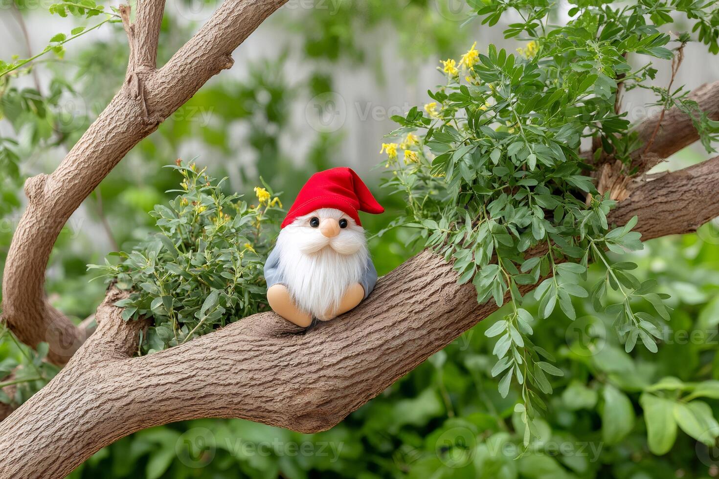 Cute garden gnome sitting on a tree branch enjoying nature photo