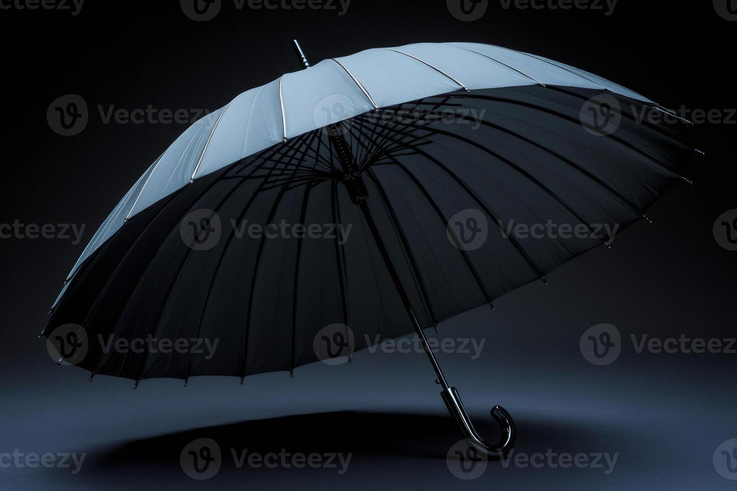 Large elegant black umbrella opened on dark background, offering protection from rain photo