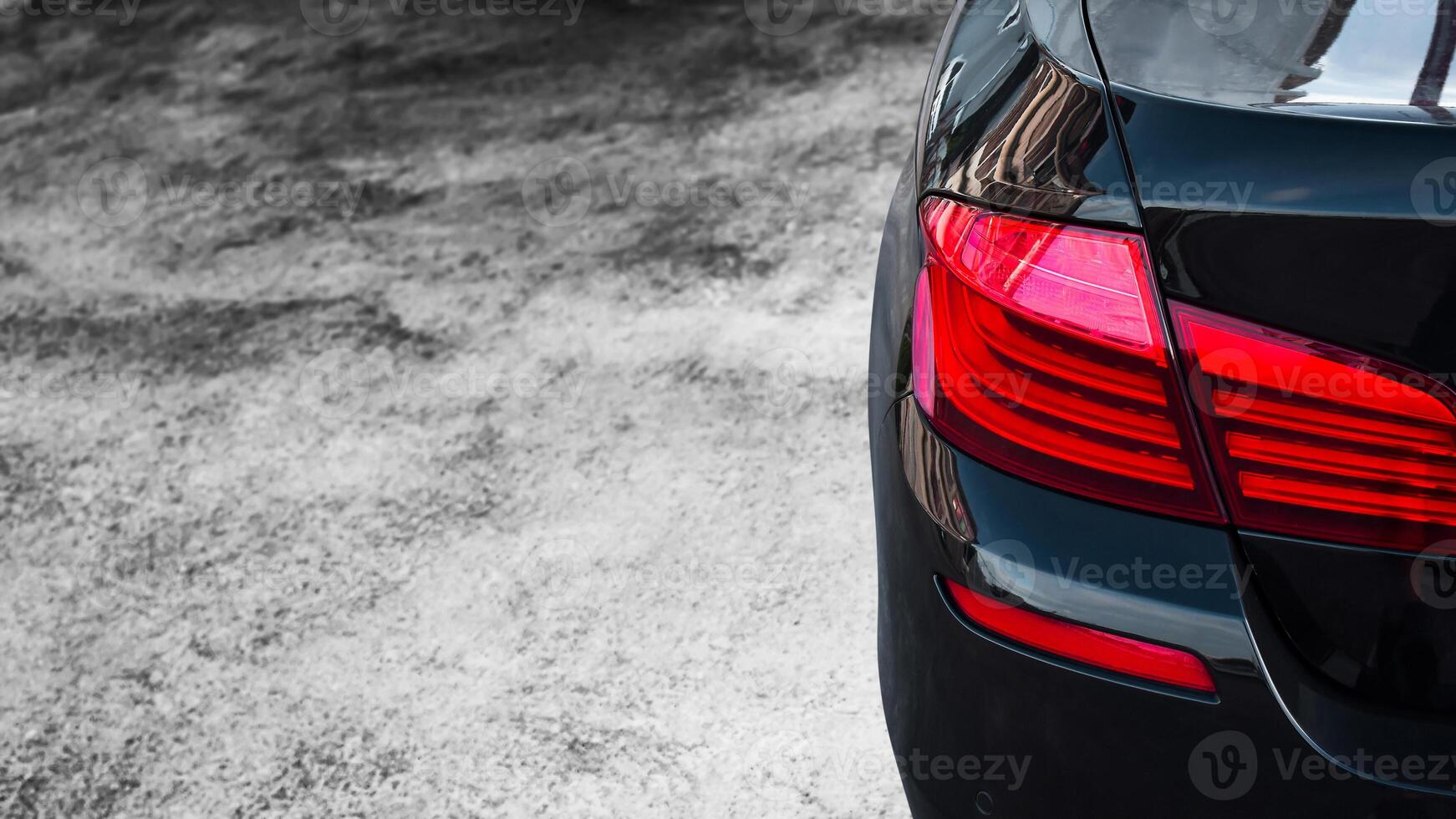Black Sedan Car with copy space, Close-up rear view of a sedan car, with a focus on its rear taillight, automotive, vehicle. photo