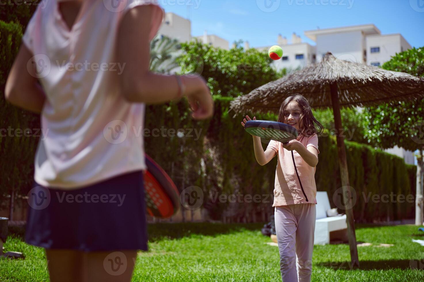 Children Playing Paddle Tennis Outdoors in Bright Summer Weather photo