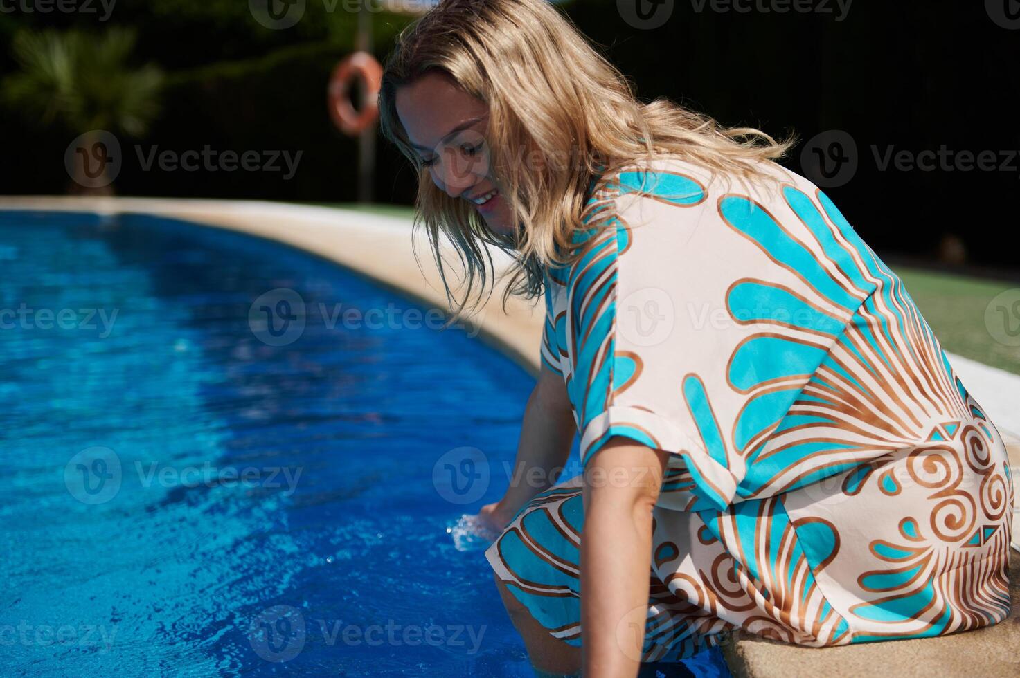 Woman Enjoying a Relaxing Poolside Moment on a Sunny Day photo
