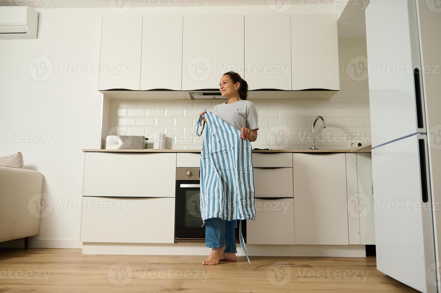 Woman Holding Apron in Modern Kitchen Interior for Domestic Lifestyle photo