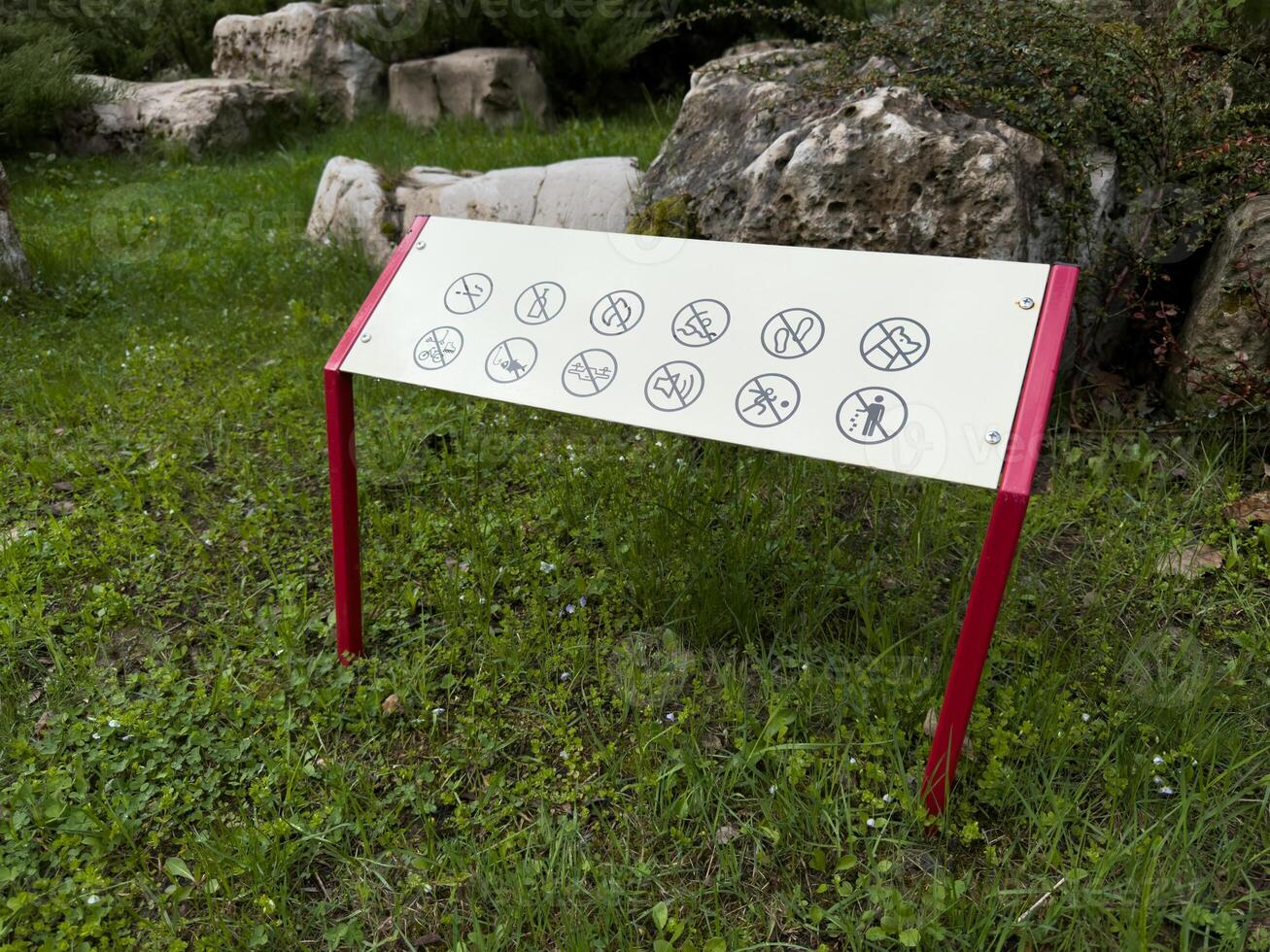 Prohibition sign in a public park with visual icons indicating restricted activities such as cycling, fishing, and littering. Clear visual design promotes safety and respectful park use photo