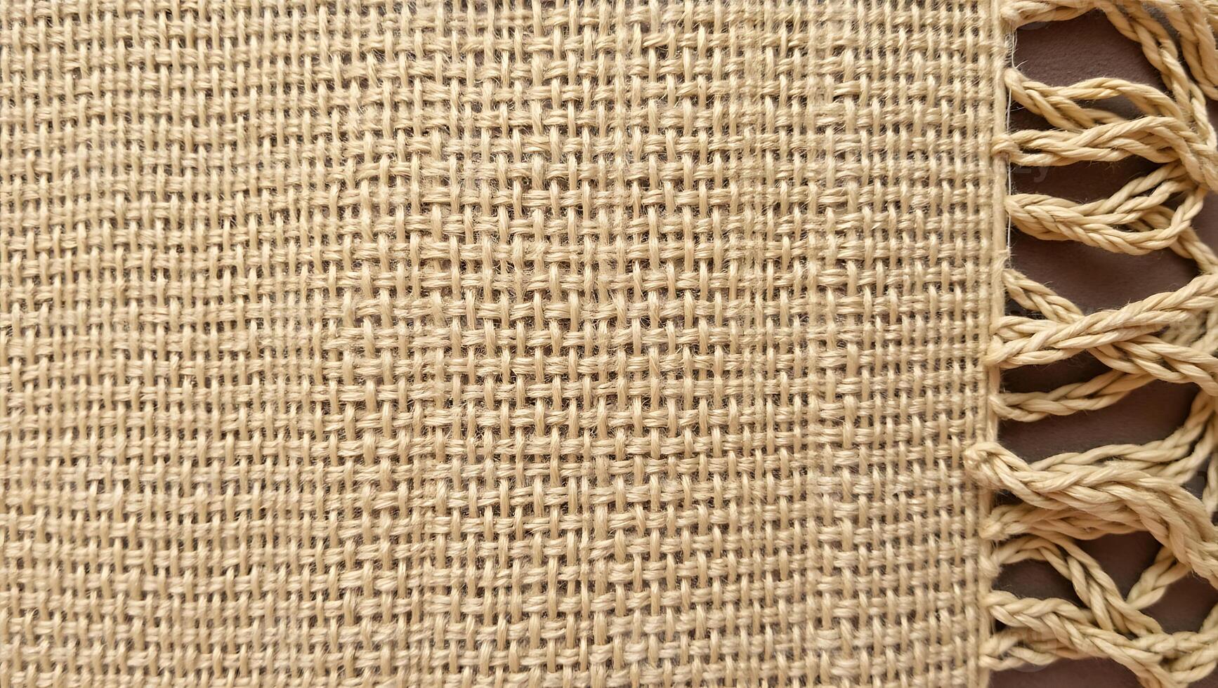 Close up view of woven burlap with decorative fringe detailed natural textile texture photo