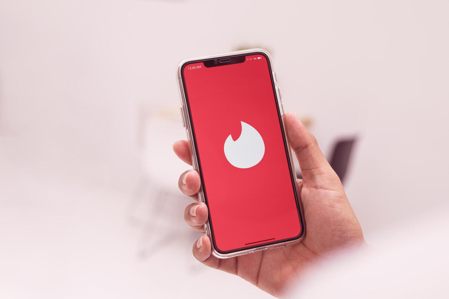 Bangkok, Thailand-12 May 2025. Popular Tinder logo on smartphone, Man opening the Tinder application on device for online dating, and finding new friends with a nearby geographic network. photo