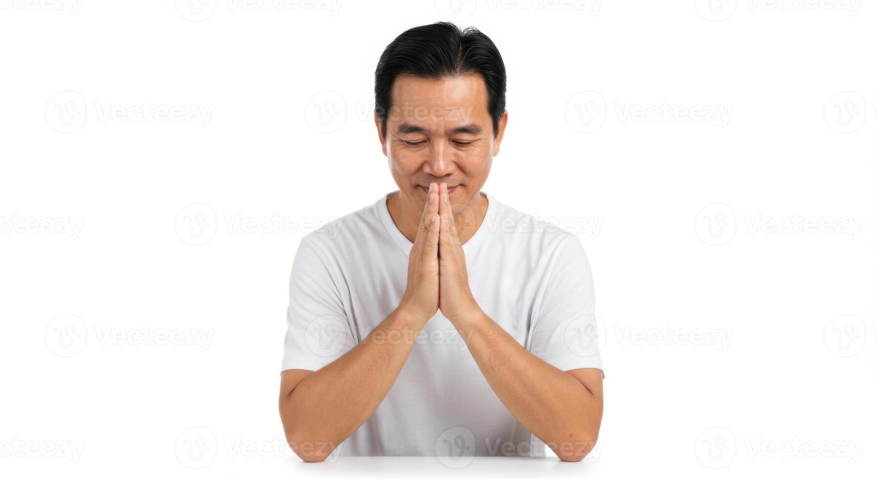 Asian Man in White T-Shirt Showing Gratitude with Praying Hands, Peaceful and Respectful Expression for Mindfulness or Wellness Concept photo