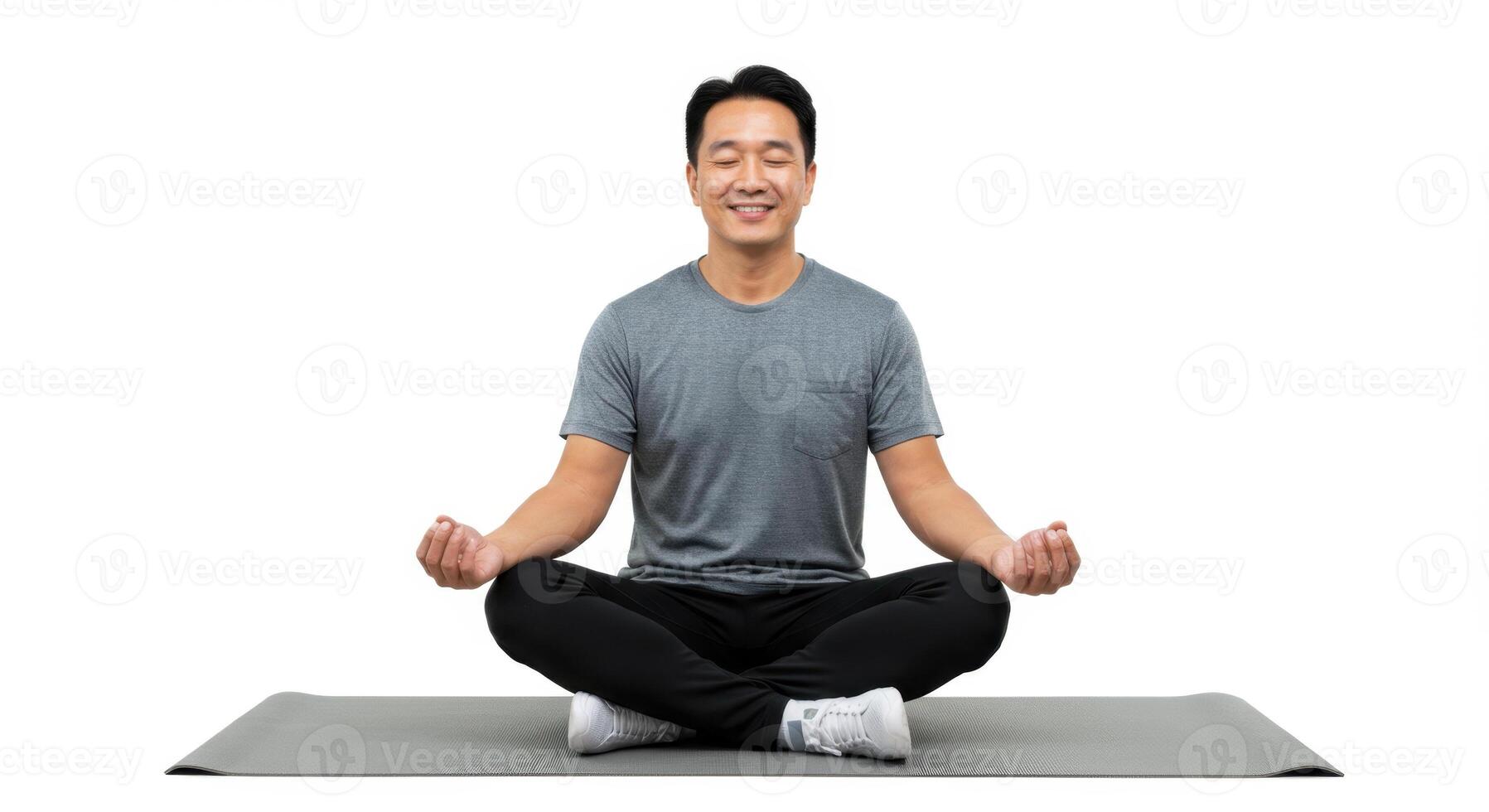 Asian Man Practicing Meditation on Yoga Mat with Eyes Closed in Peaceful Pose photo