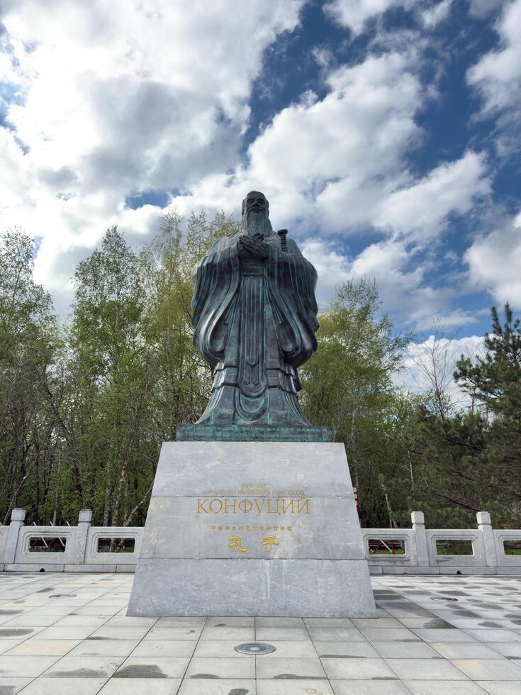 Moscow, Russia, April 25, 2025 Close up view of Confucius monument in Huamin park highlights detailed bronze sculpture and engraved pedestal, philosophical heritage and cross cultural respect photo
