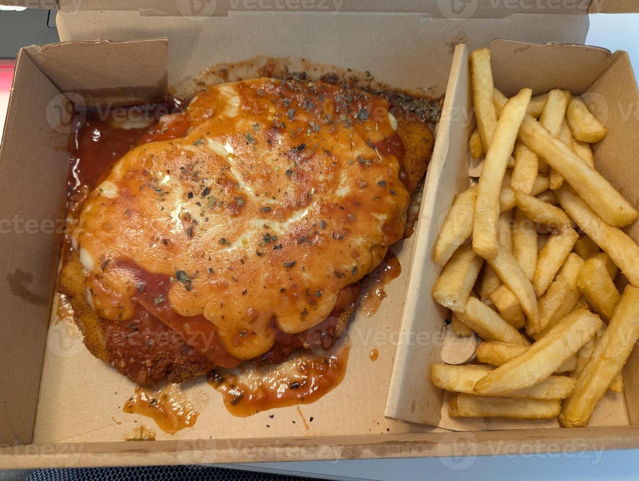 Traditional cheese chop and French fries in a cardboard delivery box photo