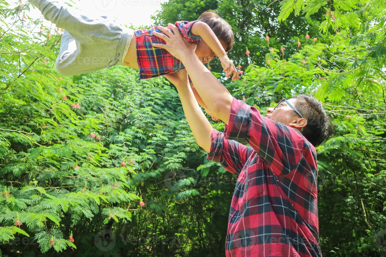 love and father lifting boy child with freedom, smile and travel celebration in nature. Flying, fun and parent with kid at the ocean for bond, happy and airplane game while traveling photo