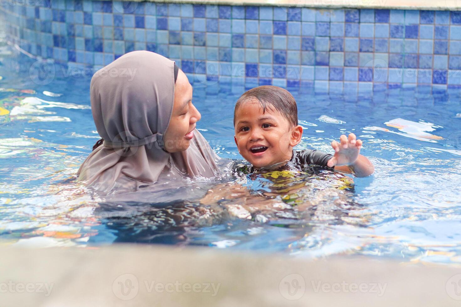 Image of mother with son in the pool photo