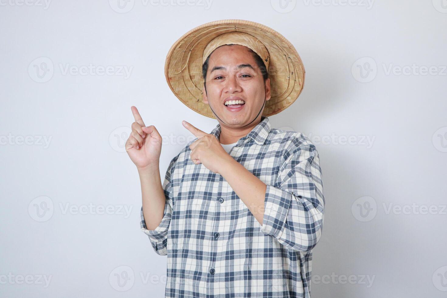 Asian farmer smiling and pointing beside him photo