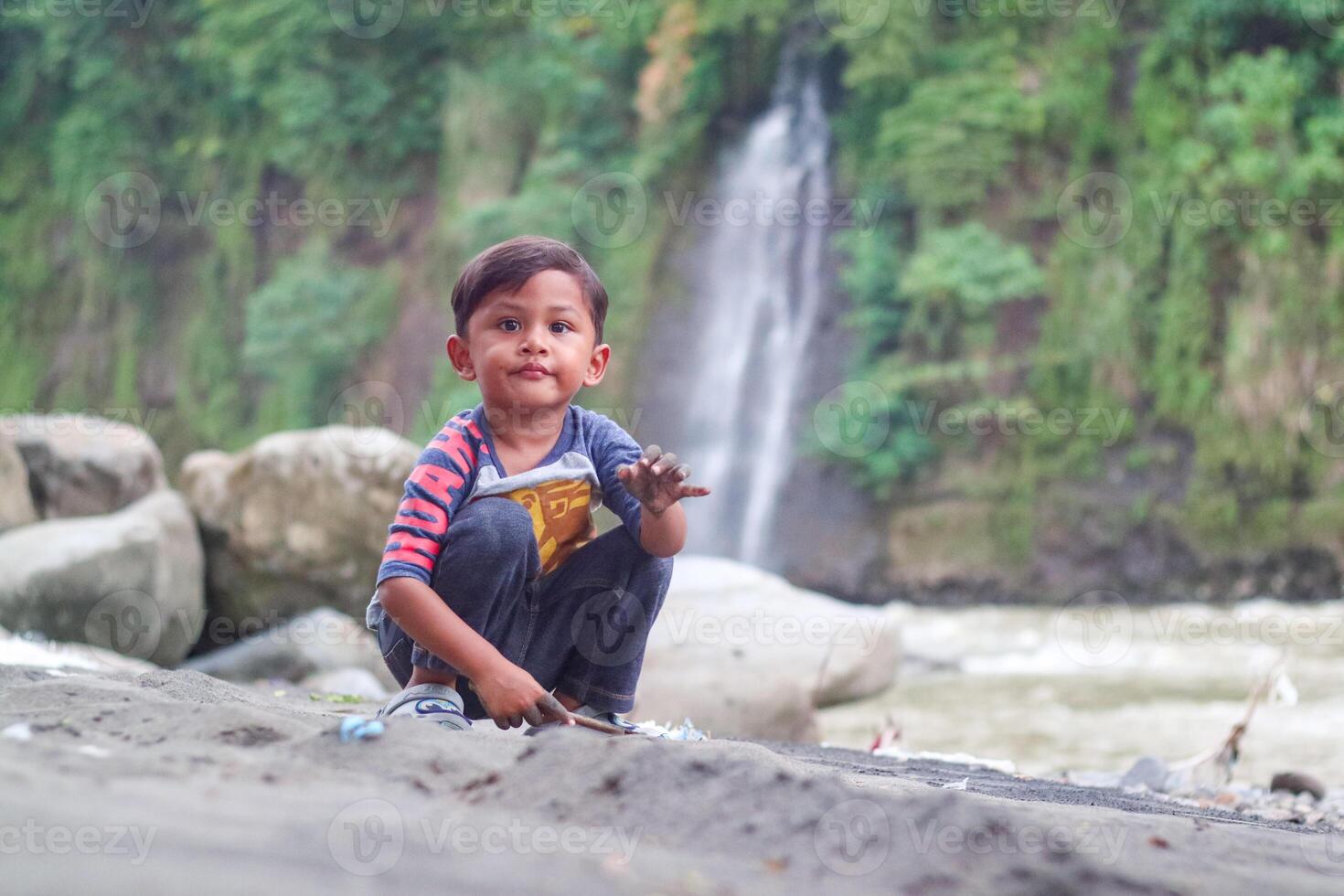 Little asian boy playing toys and sand with natural background. Fine motor skills development for little child. Soft focus. Copy space. photo