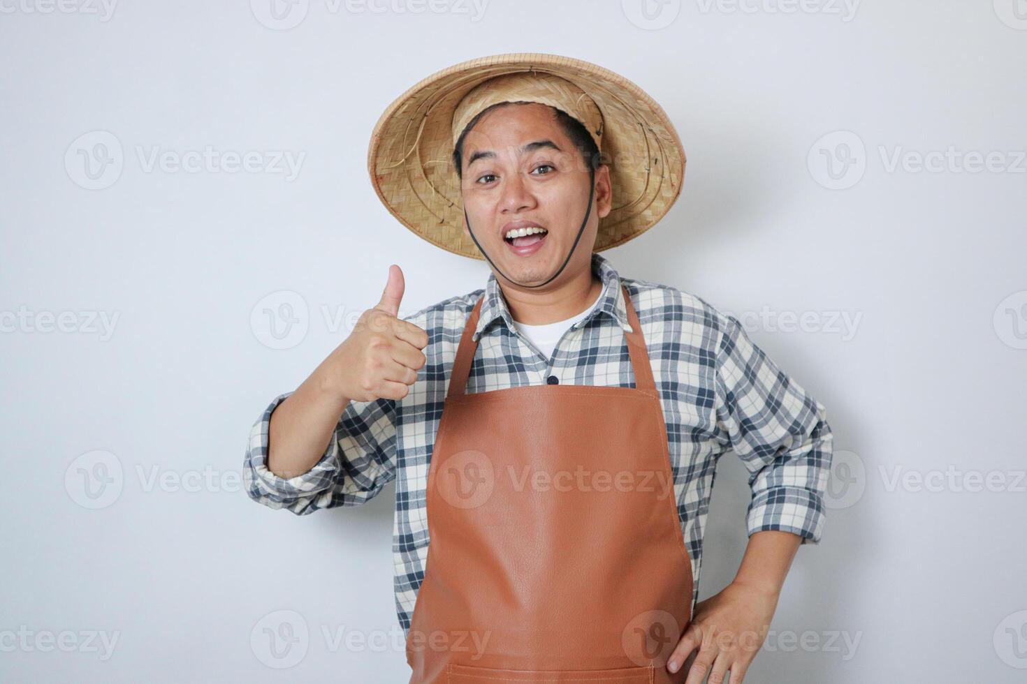 Young Indonesian farmer smiling at camera and give thumb up photo