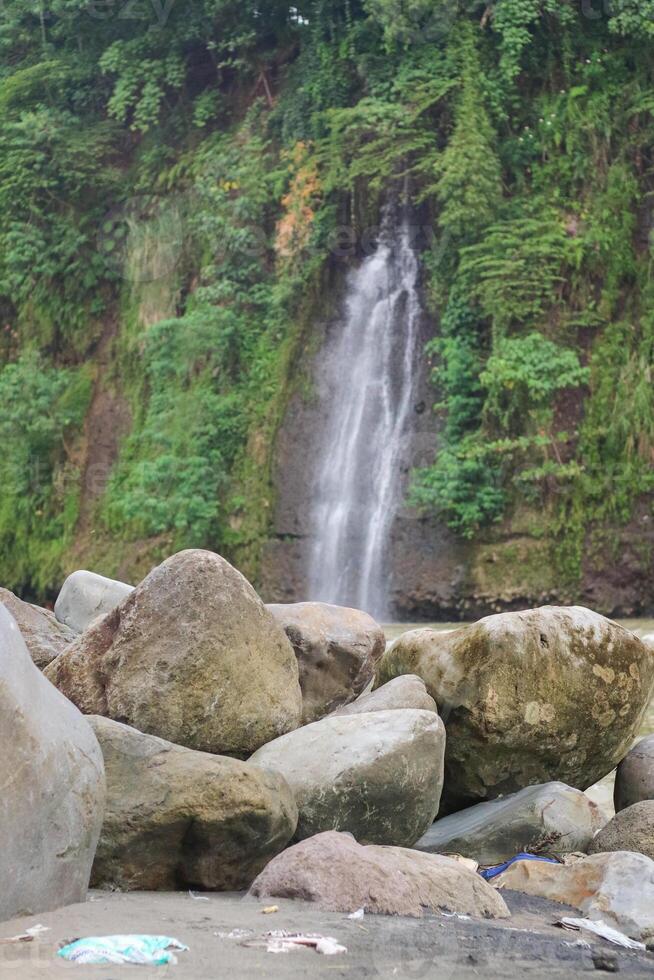 Tropical landscape. Beautiful hidden waterfall in rainforest. Adventure and travel concept. Nature background. Slow shutter speed, motion photography. Tibumana waterfall Bali, Indonesia photo