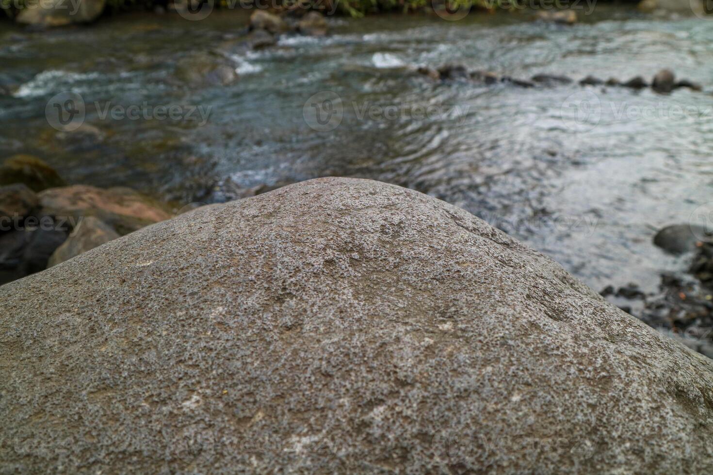 grey rock pedestal for a product display stand, green forest and blurred on the background, natural scenery landscape. photo